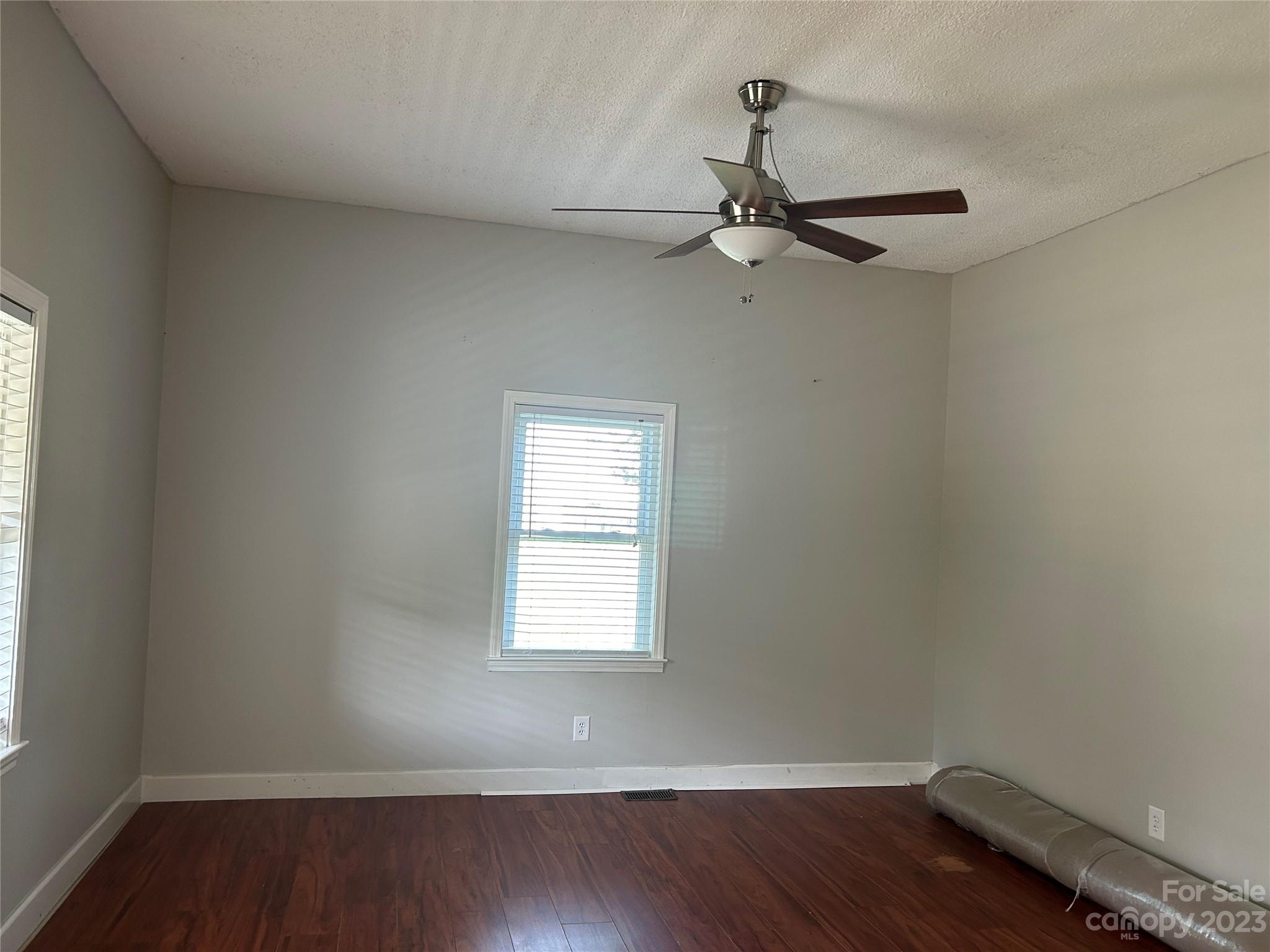211 Calhoun Street Fort Mill, SC 29715 - Photo 5 of 13 an empty room with wooden floor fan and windows