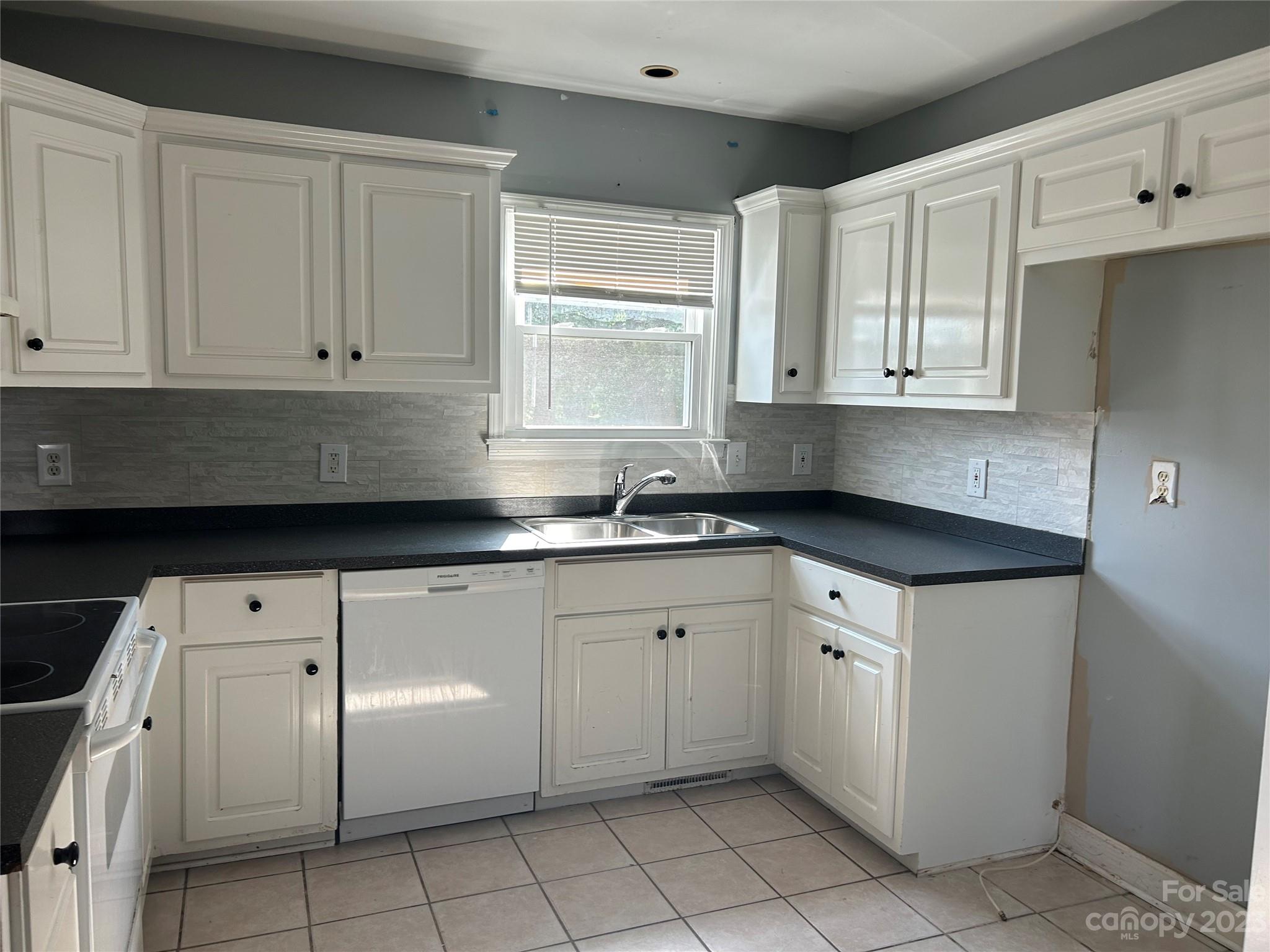 211 Calhoun Street Fort Mill, SC 29715 - Photo 6 of 13 a kitchen with granite countertop white cabinets and stainless steel appliances