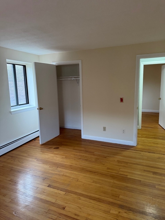 39 Linden Street, Unit 21 Boston, MA 02134 - Photo 11 of 20 a view of an empty room with wooden floor and a window