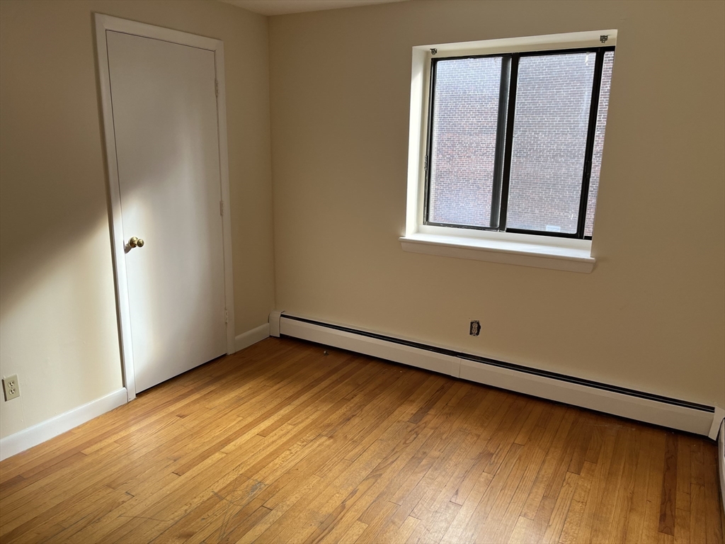 39 Linden Street, Unit 21 Boston, MA 02134 - Photo 13 of 20 a view of an empty room with window and wooden floor