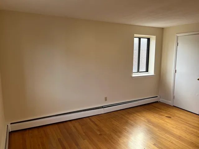 a view of a room with wooden floor and a window