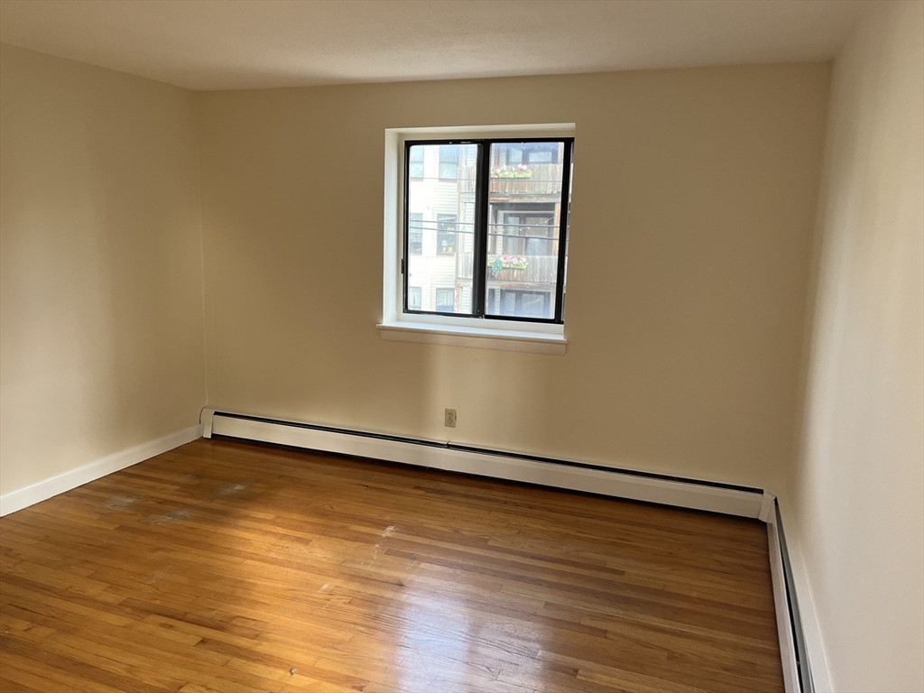39 Linden Street, Unit 21 Boston, MA 02134 - Photo 15 of 20 a view of an empty room with wooden floor and a window