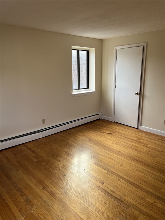39 Linden Street, Unit 21 Boston, MA 02134 - Photo 18 of 20 a view of a room with wooden floor and white walls