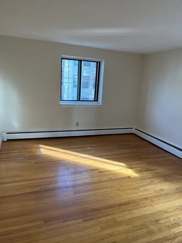 a view of a room with wooden floor and window