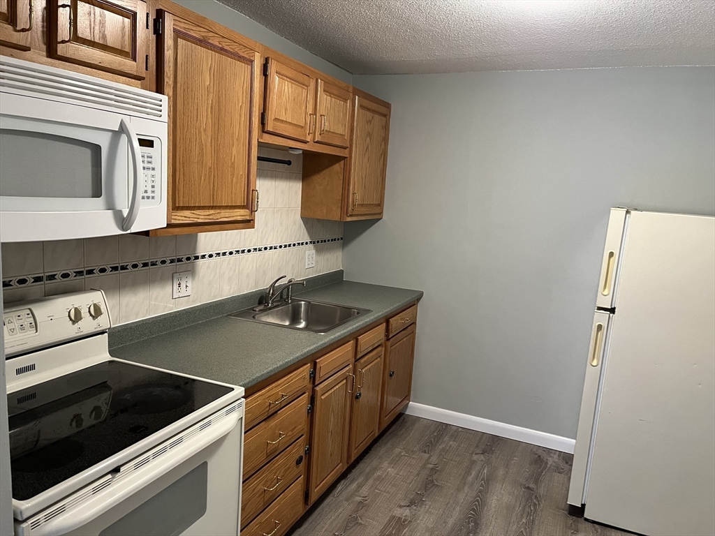 39 Linden Street, Unit 21 Boston, MA 02134 - Photo 7 of 20 a kitchen with a sink stove and microwave