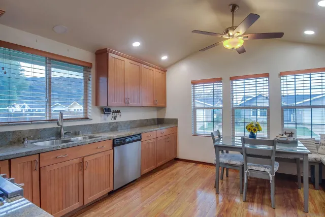 a kitchen with granite countertop wooden cabinets a sink and a window