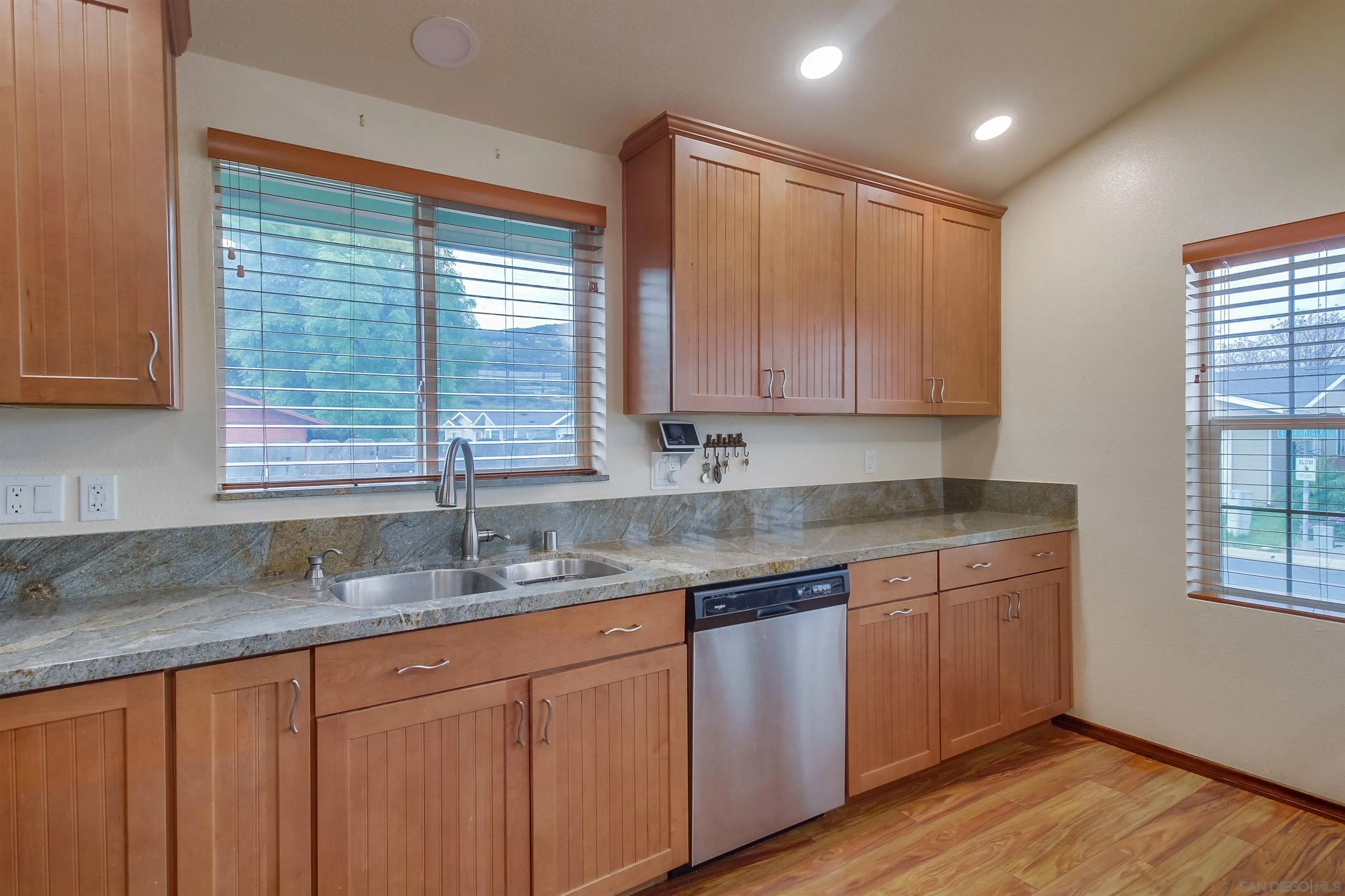 15935 Spring Oaks Road El Cajon, CA 92021 - Photo 26 of 66 a kitchen with granite countertop wooden cabinets a sink and a window