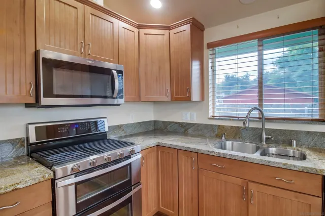 a bedroom with a bed a dresser and a large window