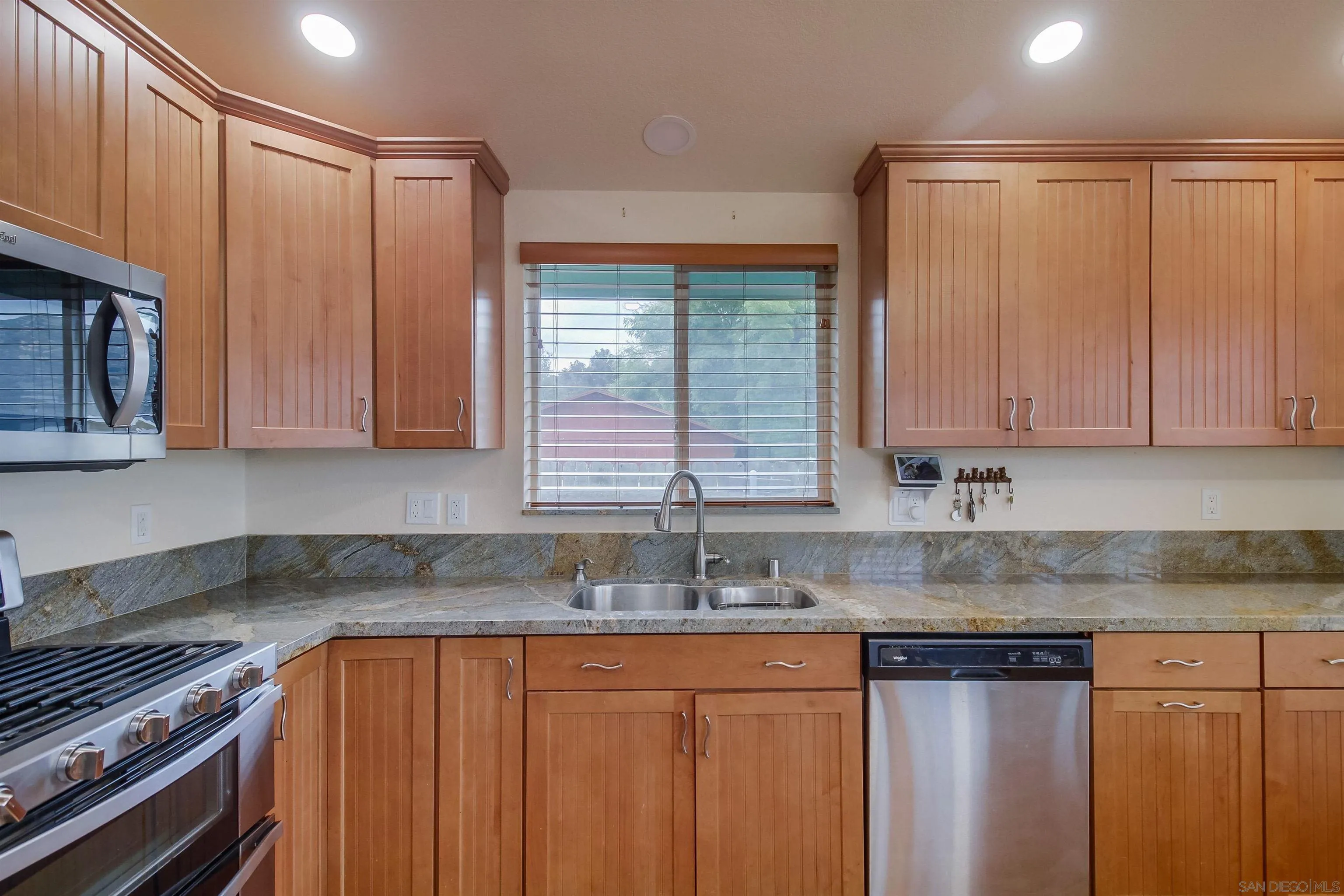 15935 Spring Oaks Road El Cajon, CA 92021 - Photo 28 of 66 a kitchen with stainless steel appliances granite countertop a sink a stove and a microwave