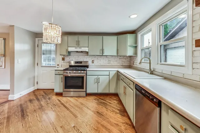 a kitchen with a sink stove top oven and cabinets