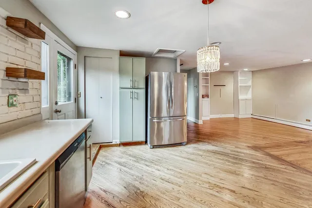 a kitchen with stainless steel appliances a refrigerator and wooden floor