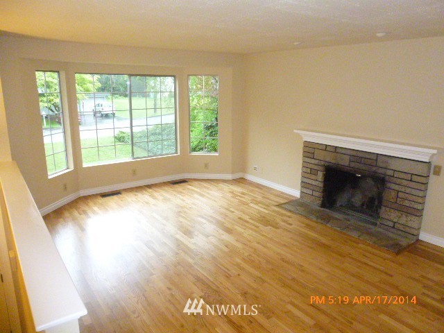 101 234th Place Southeast Bothell, WA 98021 - Photo 6 of 23 a view of empty room with wooden floor and fireplace