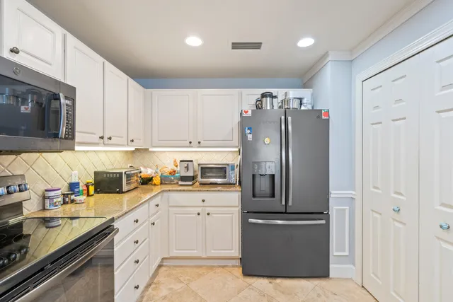 a kitchen with stainless steel appliances granite countertop a refrigerator and a stove