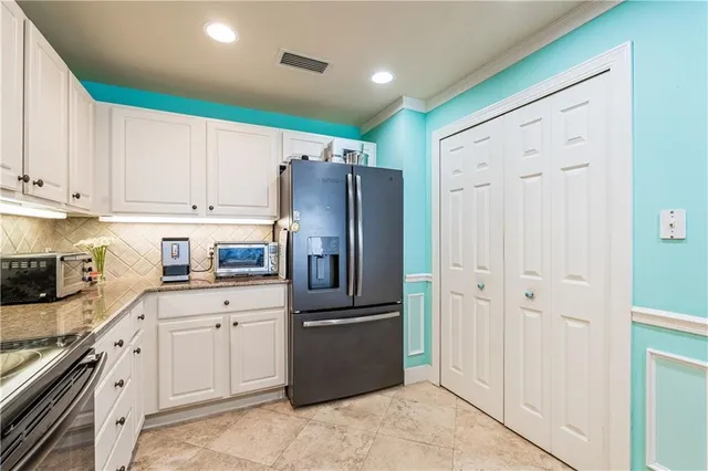 a kitchen with stainless steel appliances granite countertop a refrigerator sink and cabinets
