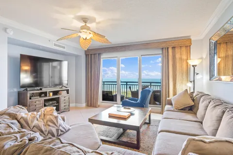 a living room with furniture and a flat screen tv next to a window