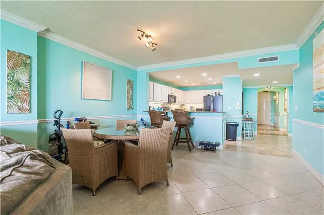a living room with couches and kitchen view with wooden floor