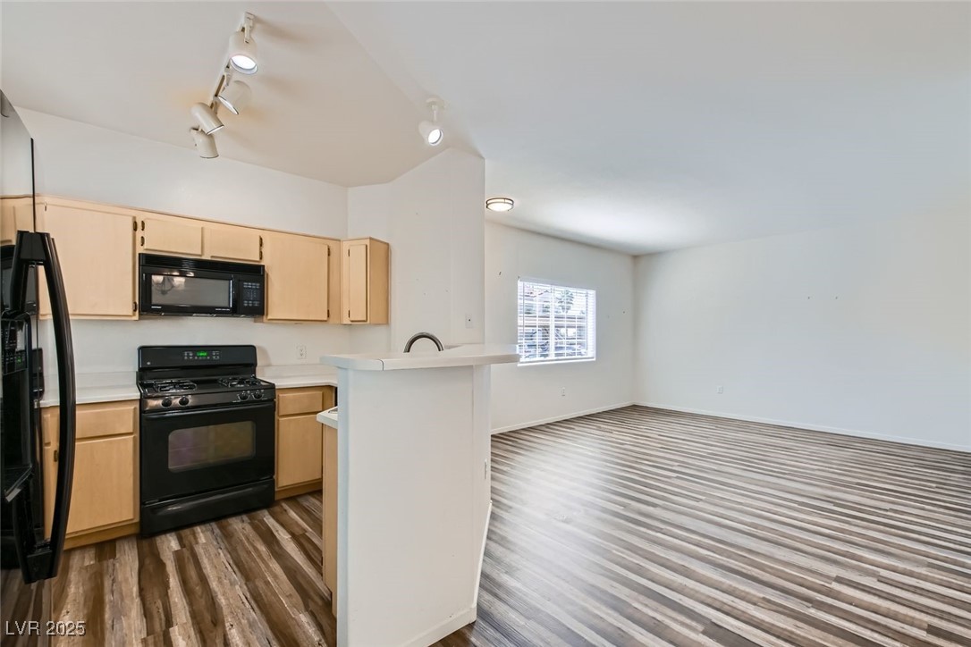 1881 West Alexander Road, Unit 1092 North Las Vegas, NV 89032 - Photo 11 of 11 Kitchen featuring black appliances, light brown cabinetry, light countertops, open floor plan, and dark wood-style flooring