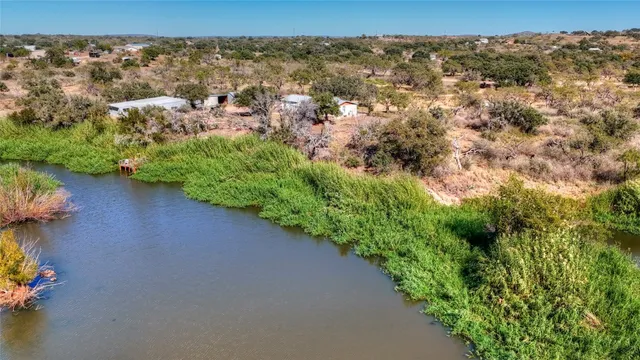 a view of house with river and trees in the background