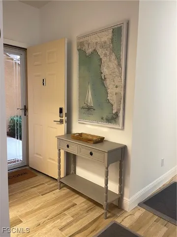 a view of a hallway with wooden floor and cabinet