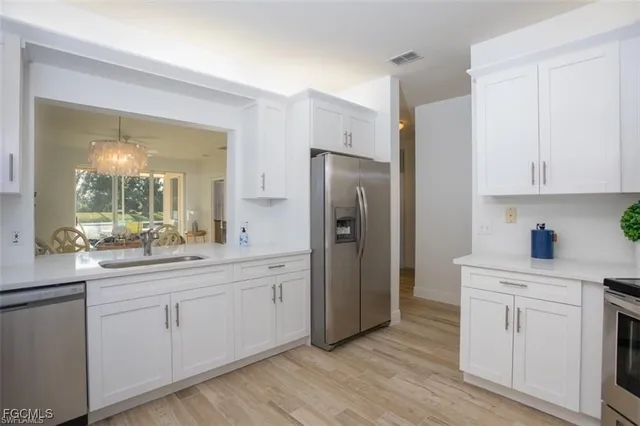 a kitchen with white cabinets and stainless steel appliances