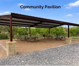 1059 Sweeney Way Weatherford, TX 76087 - Photo 36 of 37 Expansive pavilion featuring a metal roof, structural steel beams, stone-clad column bases, and a gravel surface