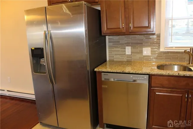 a kitchen with stainless steel appliances granite countertop a refrigerator and a sink