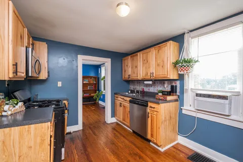a kitchen with granite countertop wooden floors and stainless steel appliances