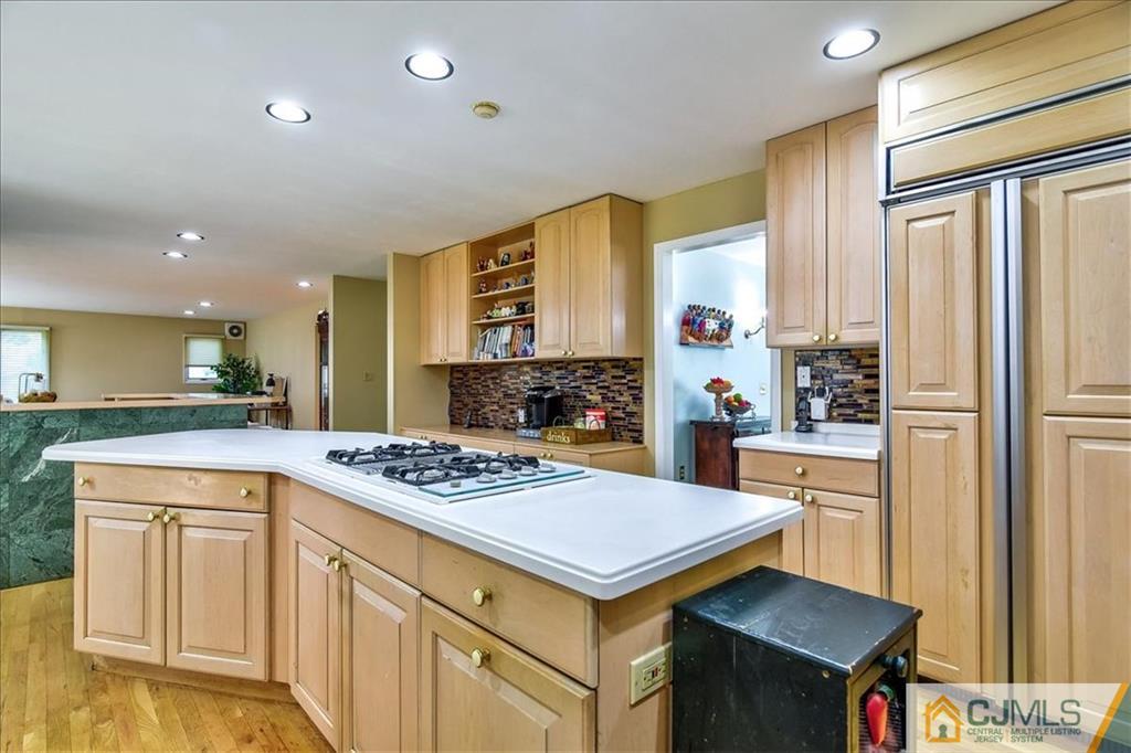 19 Thomas Road East Brunswick, NJ 08816 - Photo 15 of 37 a kitchen with a stove a sink dishwasher and white cabinets with wooden floor