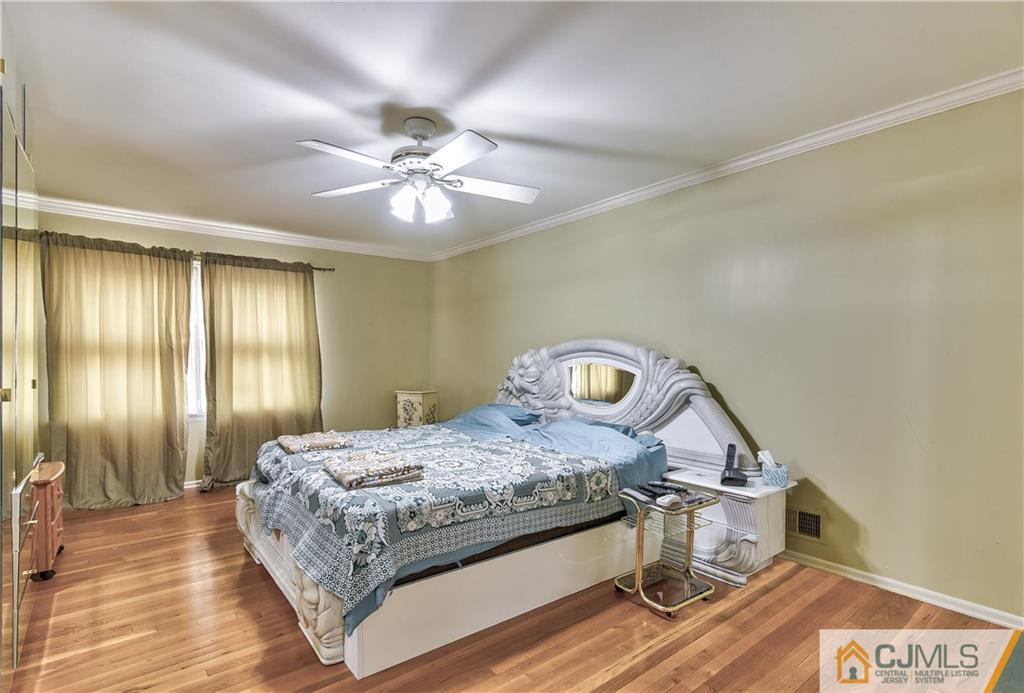 19 Thomas Road East Brunswick, NJ 08816 - Photo 24 of 37 a bedroom with a bed and a chandelier