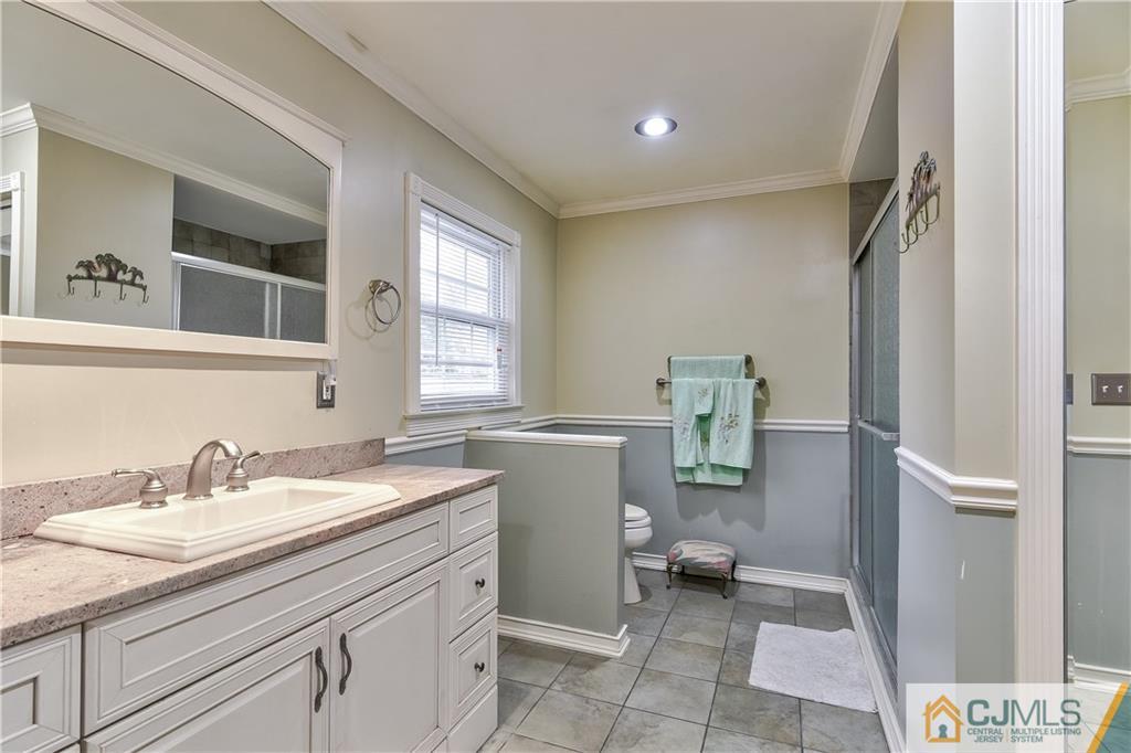 19 Thomas Road East Brunswick, NJ 08816 - Photo 27 of 37 a bathroom with a sink a toilet and a mirror