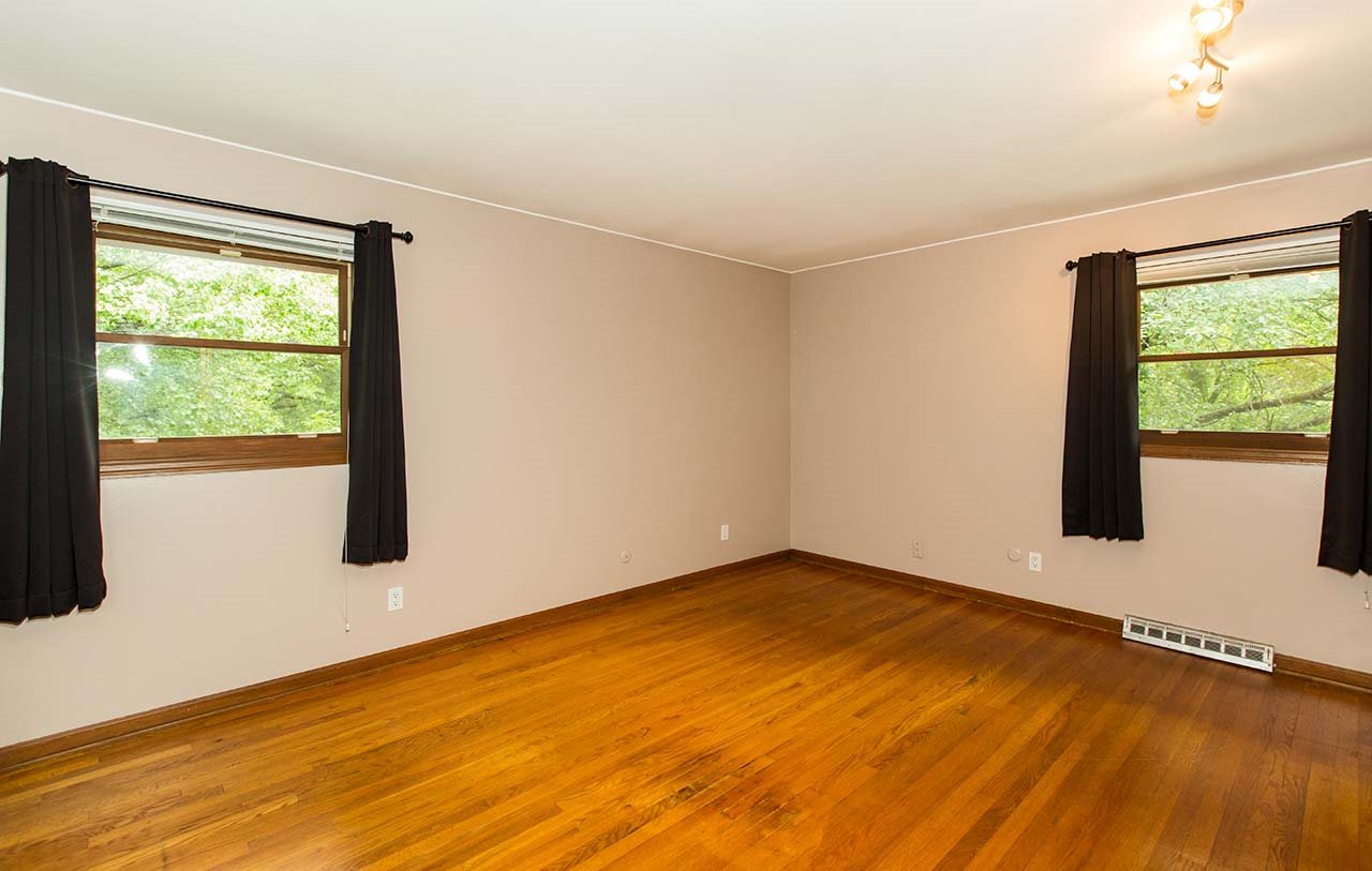5221 Brookview Road Rockford, IL 61107 - Photo 12 of 25 a view of an empty room with a window and wooden floor