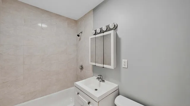 a bathroom with a sink a toilet and shower