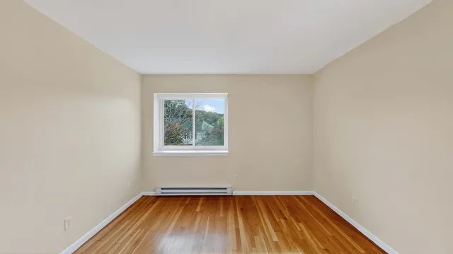 a view of a room with wooden floor and window
