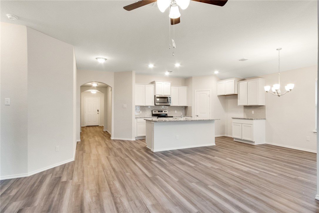 117 Nathaniel Drive Taylor, TX 76574 - Photo 5 of 26 a large kitchen with kitchen island a sink stainless steel appliances and cabinets