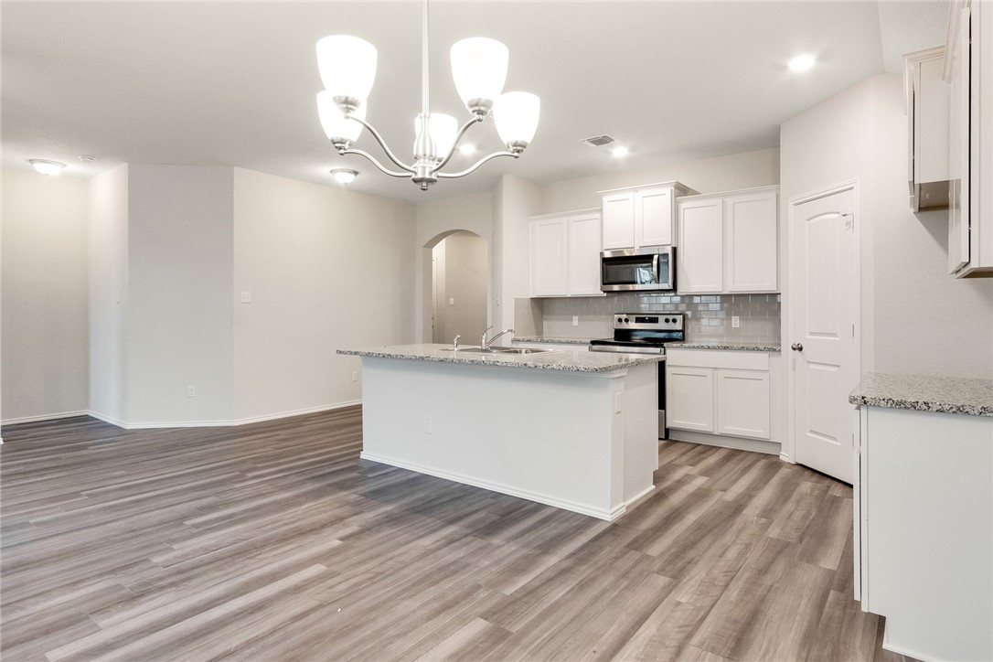 117 Nathaniel Drive Taylor, TX 76574 - Photo 6 of 26 a kitchen with a refrigerator and a stove top oven