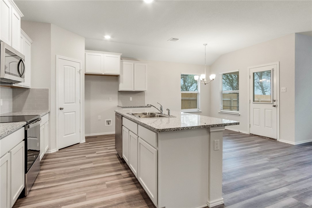 117 Nathaniel Drive Taylor, TX 76574 - Photo 8 of 26 a kitchen with granite countertop a sink and a stove top oven