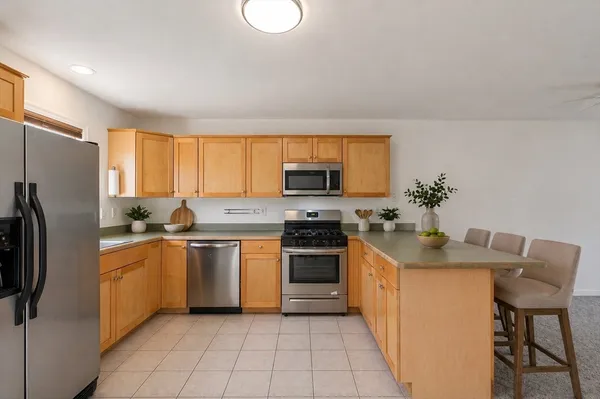 a kitchen with stainless steel appliances granite countertop a stove a sink and a refrigerator
