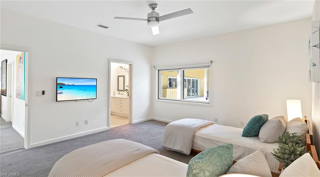 586 Yucca Road Naples, FL 34102 - Photo 16 of 26 Bedroom featuring a ceiling fan, carpet flooring, and ensuite bath