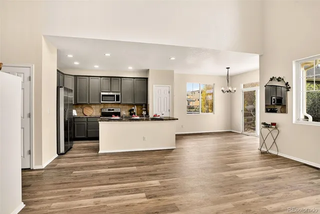 a view of a room with wooden floor chandelier and windows