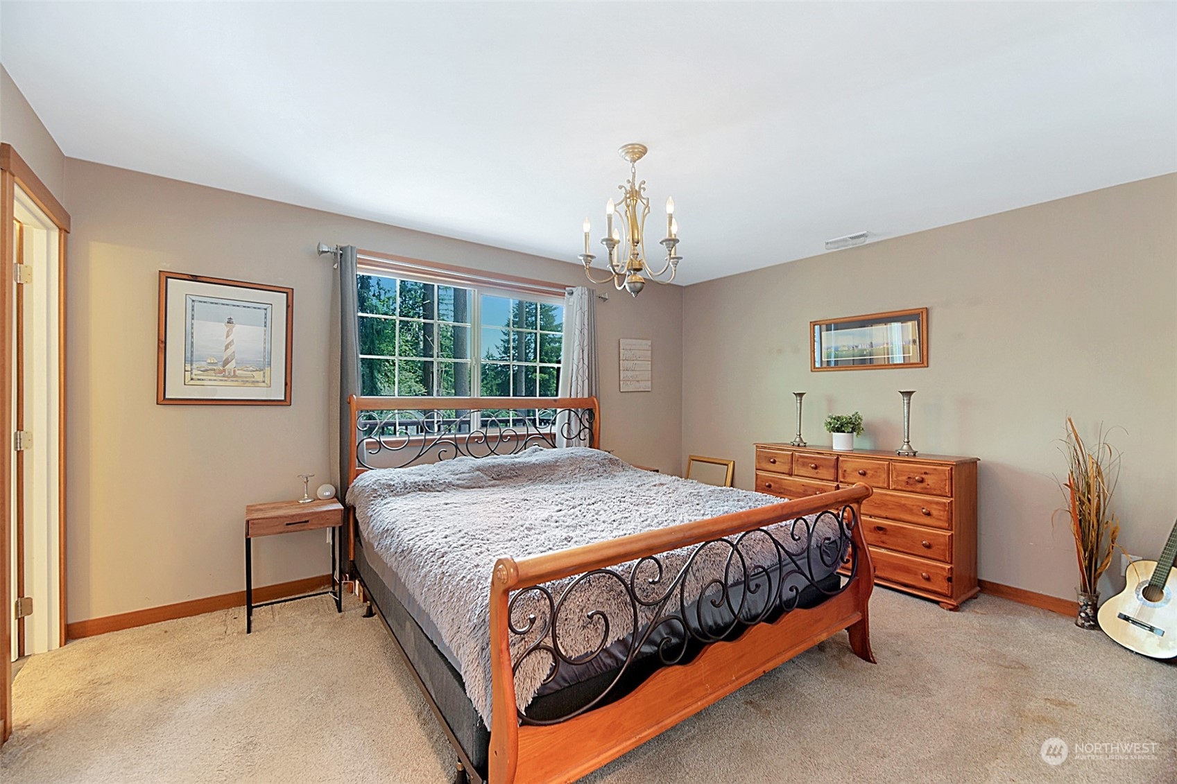 907 Harvest Road Bothell, WA 98012 - Photo 14 of 28 a bedroom with a bed chandelier and a window