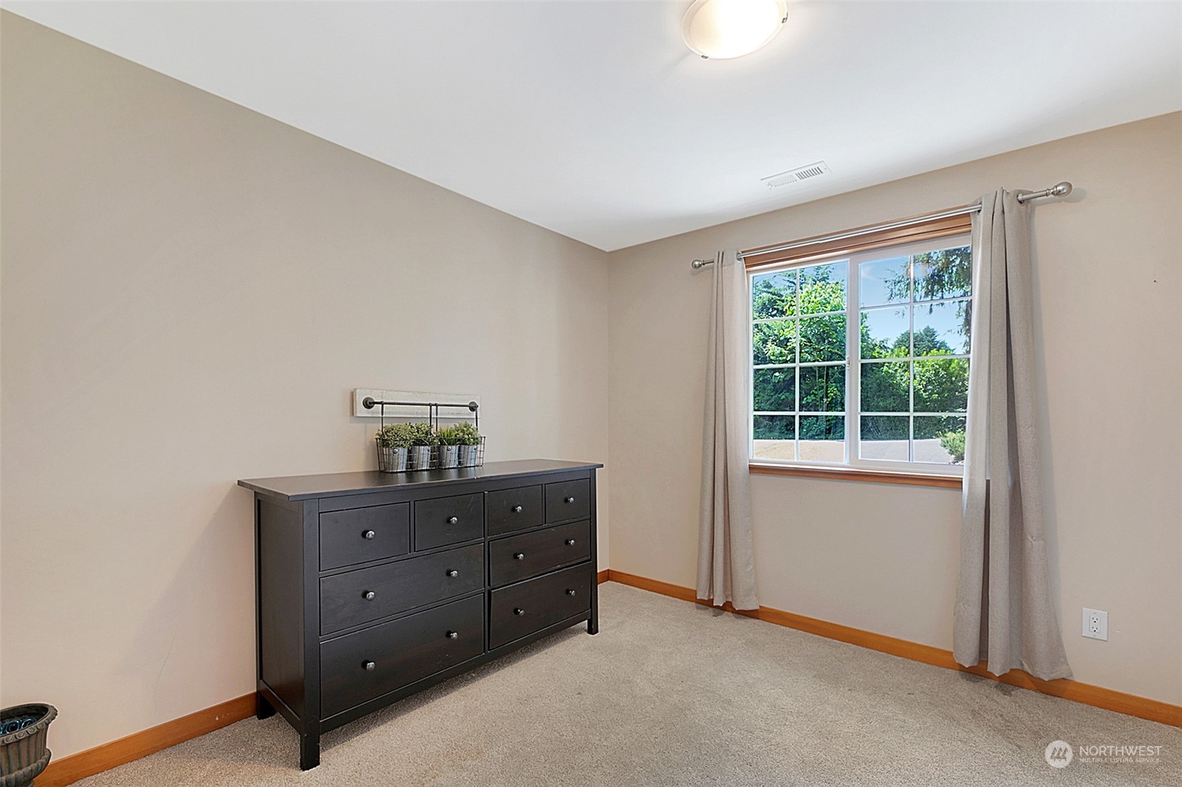 907 Harvest Road Bothell, WA 98012 - Photo 16 of 28 a room with a dresser and a window