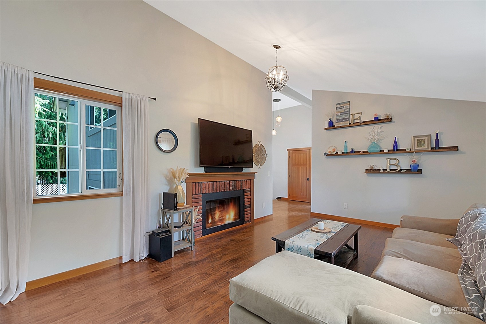 907 Harvest Road Bothell, WA 98012 - Photo 4 of 28 a living room with furniture a flat screen tv and a fireplace