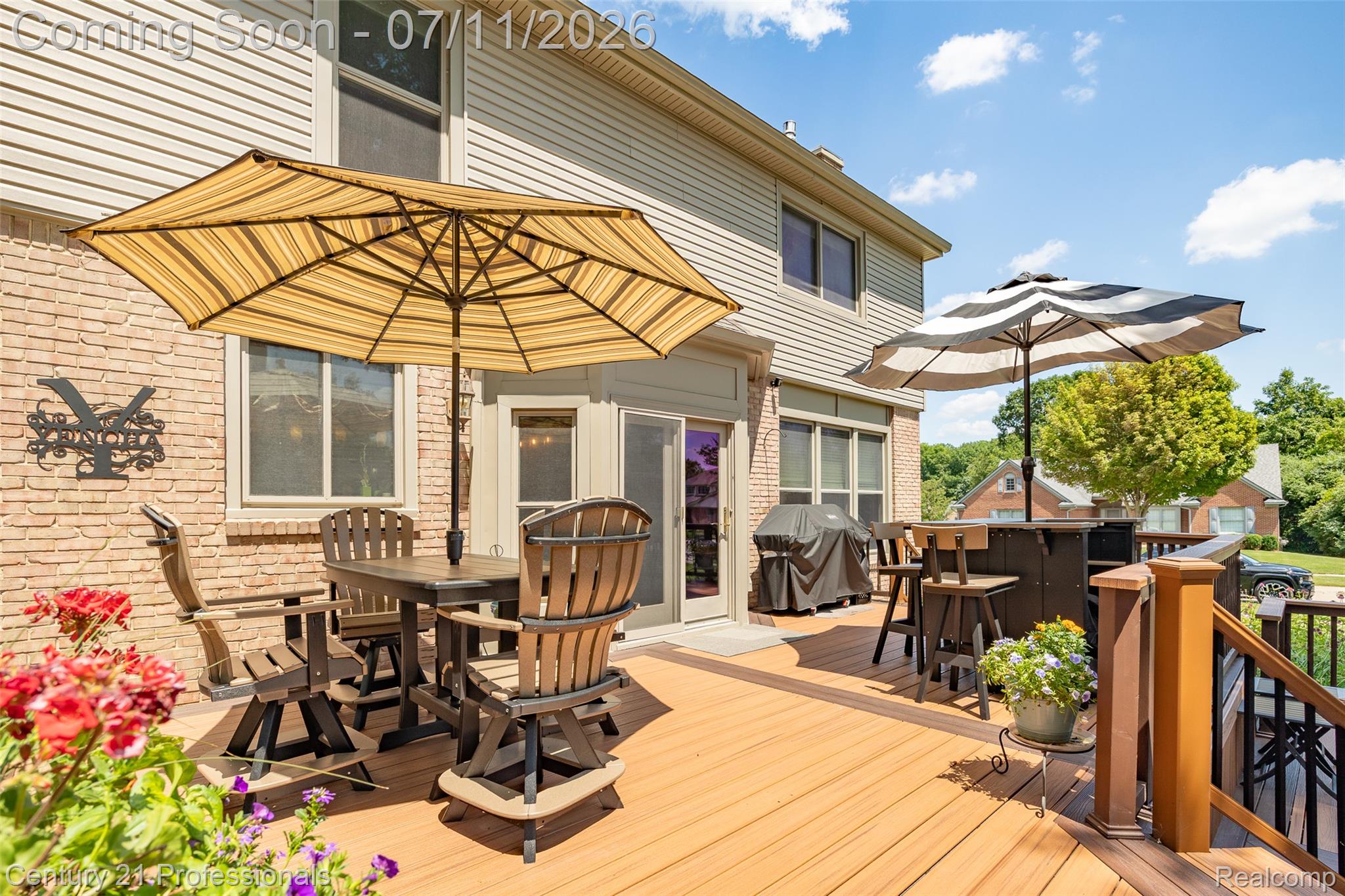 689 Woodfield Way Rochester, MI 48307 - Photo 18 of 61 Spacious outdoor deck featuring wood-finish decking, dark wood railings, and a brick exterior with vinyl siding
