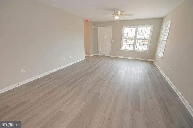 a kitchen with a refrigerator and wooden floor