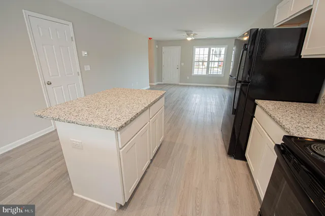 a kitchen with granite countertop wooden cabinets granite counter tops and a hard wood floor