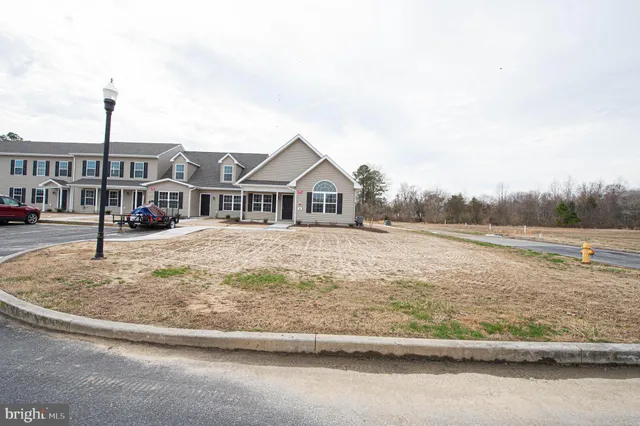 a view of a house with a wooden deck and a yard