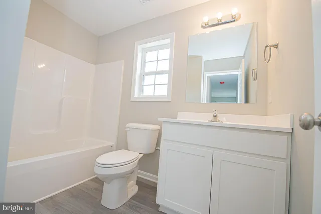 an empty room with a window and a ceiling fan