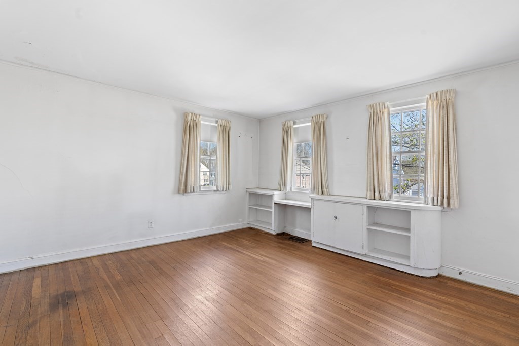 160 Reservoir Road Chestnut Hill, MA 02467 - Photo 14 of 42 an empty room with wooden floor and windows