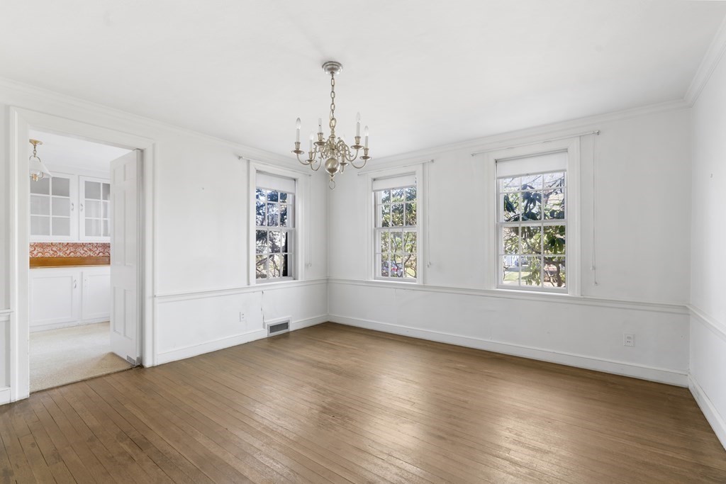 160 Reservoir Road Chestnut Hill, MA 02467 - Photo 9 of 42 an empty room with wooden floor chandelier and windows