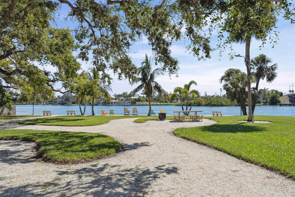 6415 Midnight Pass Road, Unit 211 Sarasota, FL 34242 - Photo 49 of 58 a view of a swimming pool with a yard and palm trees